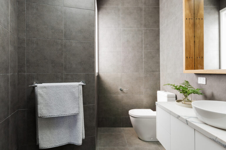 Charcoal grey modern bathroom with marble benctop and wood mirror